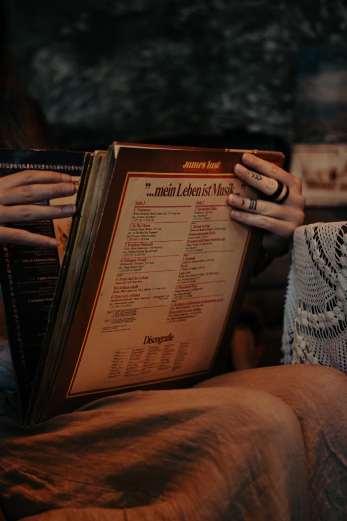 Hands exploring a collection of vintage vinyl records with a cozy, warm atmosphere.