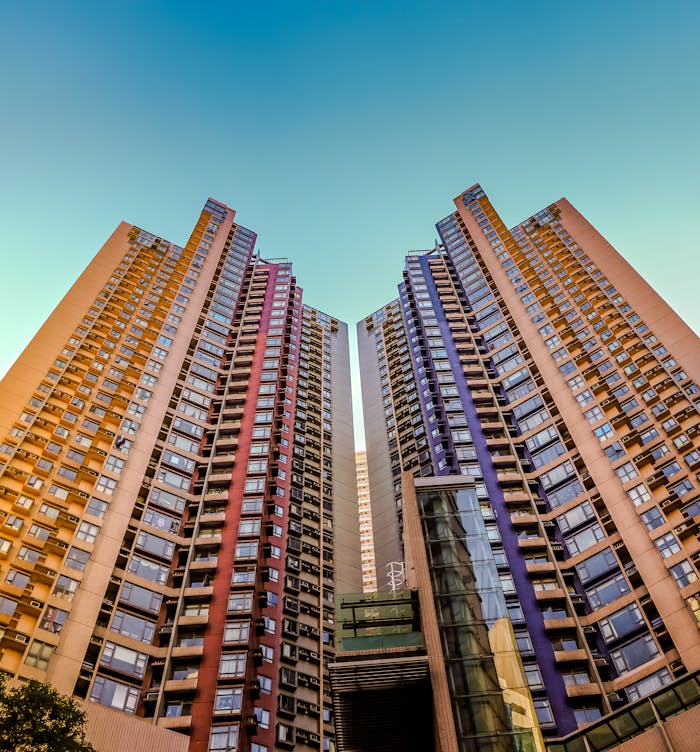 Services-03 Tall, colorful skyscrapers reaching into the blue sky in Hong Kong, showcasing modern architecture.